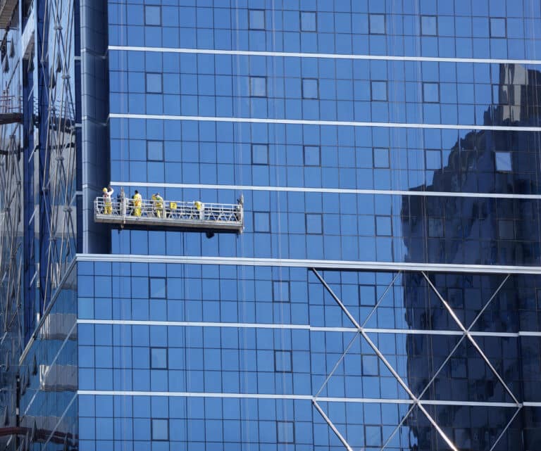 Mitarbeiter von Bavaria Cleaning führen Glasreinigung an Fassade eines Hochhauses durch