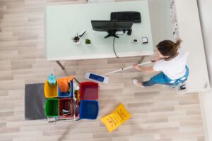Von oben Blick auf Mitarbeiterin von Bavaria Cleaning, die eine Büroreinigung durchführt